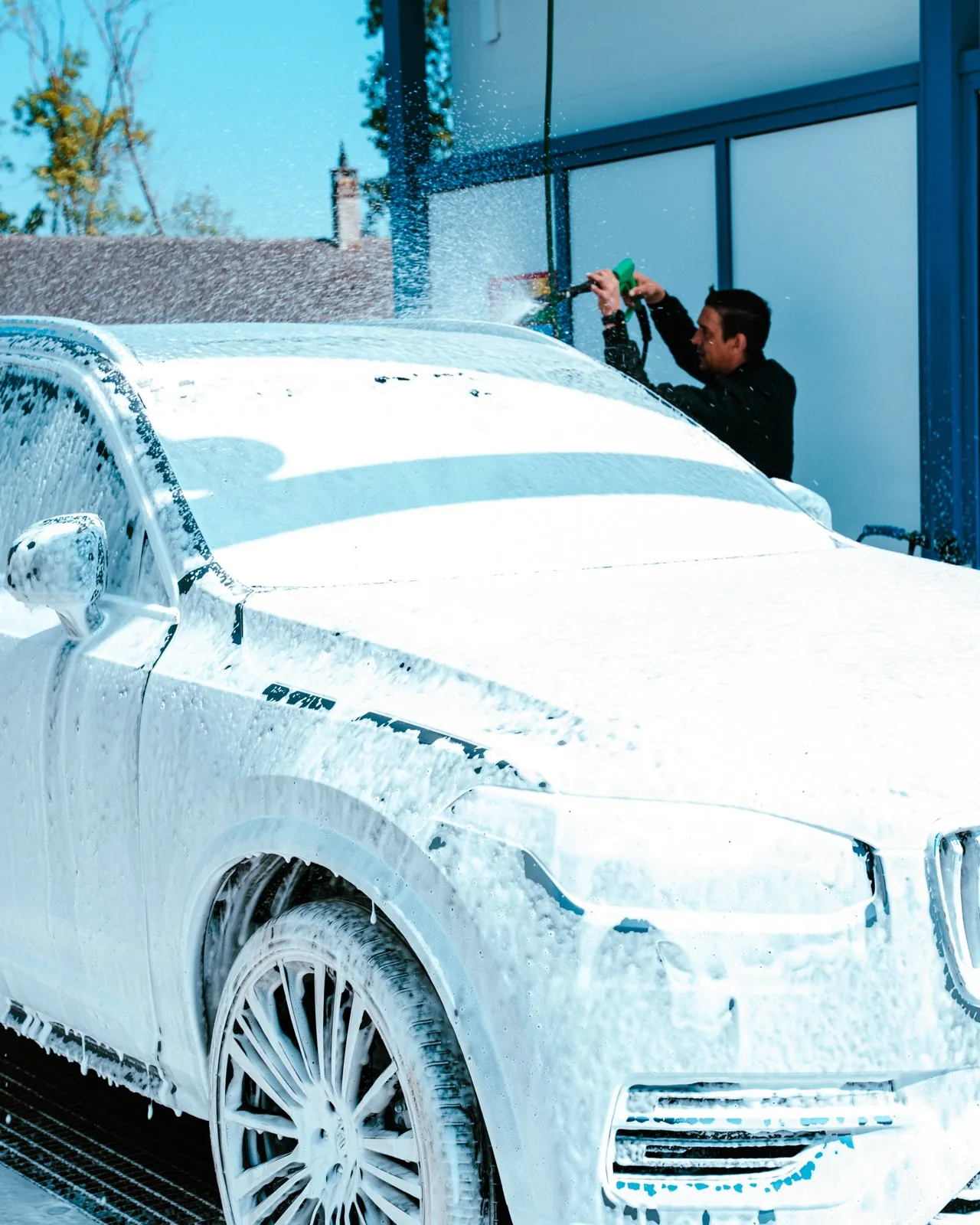 Véhicule recouvert de mousse sous une station Hydrowash